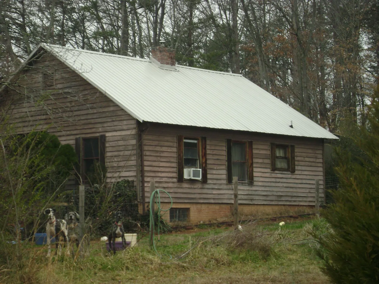 White metal roof on an old wood sided farmhouse, from a Metal Roof Installation job in Alexander